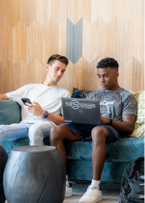 two young men using a laptop